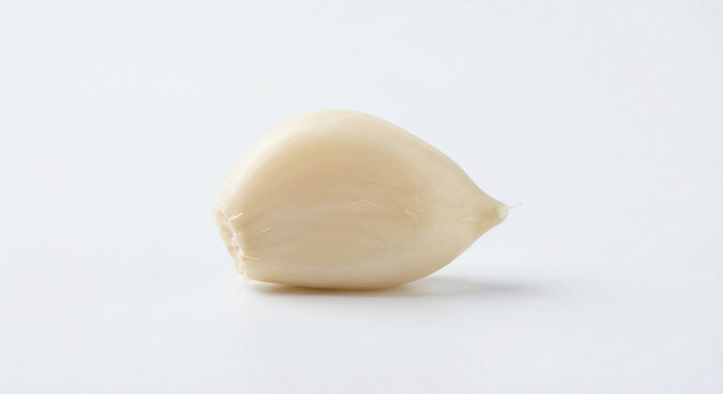 Single peeled garlic clove on a white background, closeup studio food product shot.

