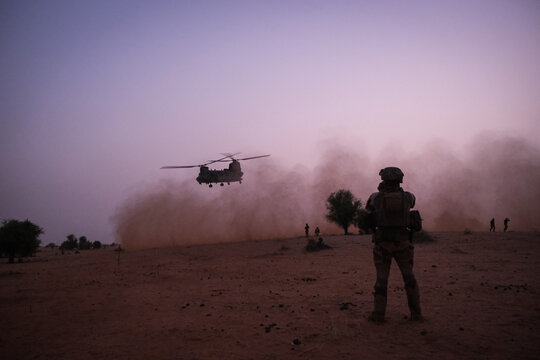 French soldier watching a military helicopter fly away in the Sahel near Tin-Akoff, Burkina Faso