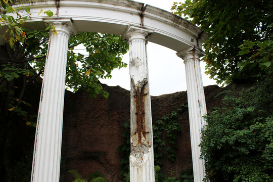 Ancient stone columns in a park. A stone structure from a past century.