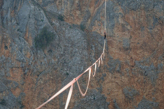 Highline sagging in a long curve over the void of the Red Lake karst sinkhole near Imotski, Croatia