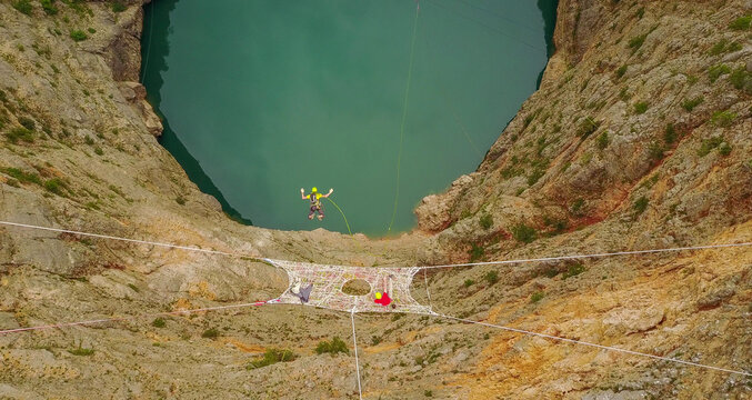 Hammock hanging on a highline across the Red Lake karst sinkhole near Imotski, Croatia