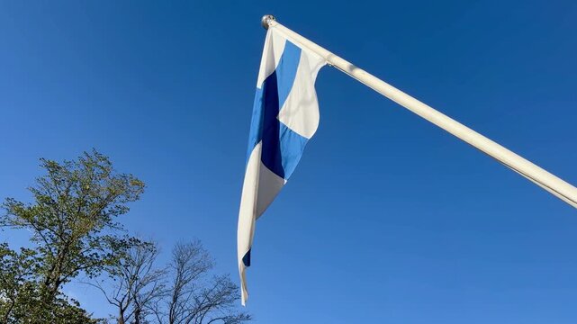 Flag of Finland Waving Gently Against a Clear Blue Sky