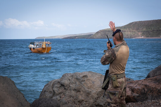 Instructor directing a boat by radio during French Army officer cadet combat and hardening training in Djibouti