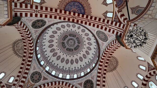Low angle view of ornate mosque dome with islamic calligraphy and beautiful ottoman design.