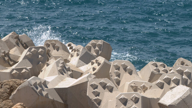 Concrete Tetrapod Breakwater Blocks Along Rocky Seacoast