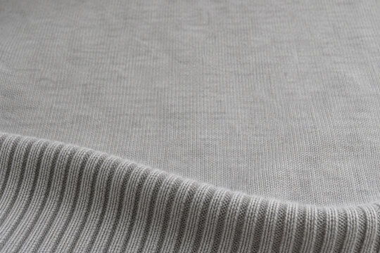 Soft merino ribbing curving toward a quiet gray field