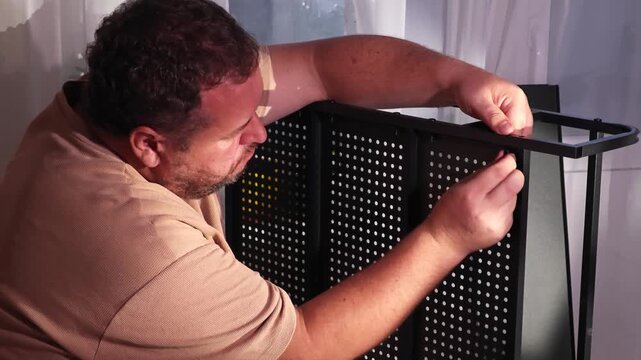 a man assembles a metal cabinet