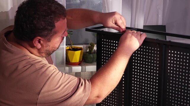 a man assembles a metal cabinet