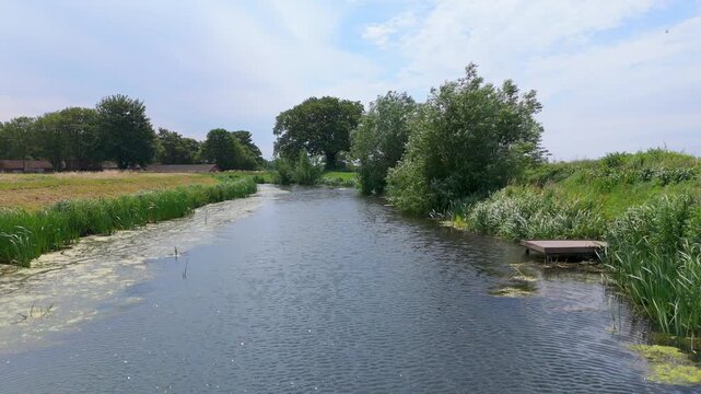 Calm river flows through green countryside