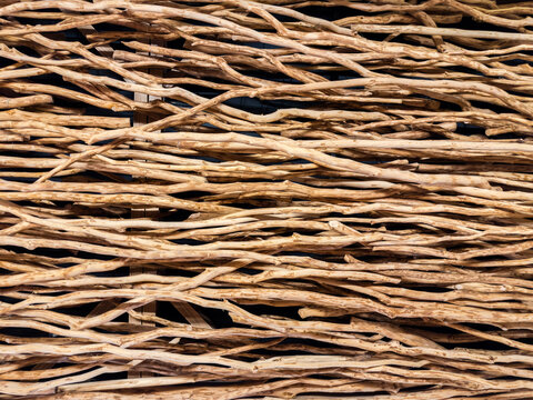 Decorative partition made with intertwined wooden branches peeled from bark