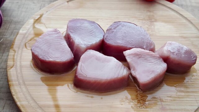 Raw swordfish steaks on wooden cutting board fresh seafood preparation for cooking.