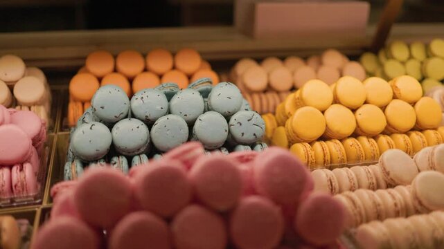 Colorful French macarons arranged in rows behind a glass display at a pastry shop showcasing assorted flavors bright colors and elegant sweet desserts