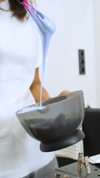 Women's Hair Salon. The stylists at the women's salon are working with a young woman. Beauty salon and makeup - vertical video.