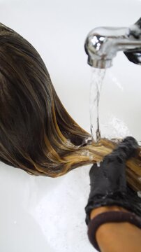 Women's Hair Salon. The stylists at the women's salon are working with a young woman. Beauty salon and makeup - vertical video.