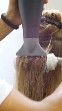 Women's Hair Salon. The stylists at the women's salon are working with a young woman. Beauty salon and makeup - vertical video.