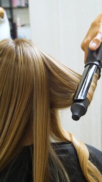 Women's Hair Salon. The stylists at the women's salon are working with a young woman. Beauty salon and makeup - vertical video.