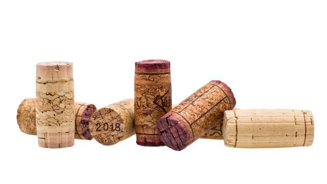 Collection of used natural wine corks with text and vintage stains, arranged in a horizontal row on a black background, wine industry concept