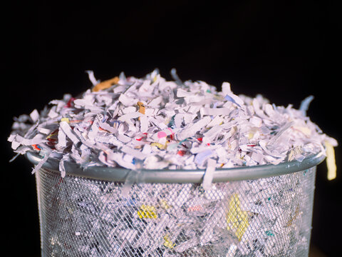 Paper shredder bin filled with shredded documents