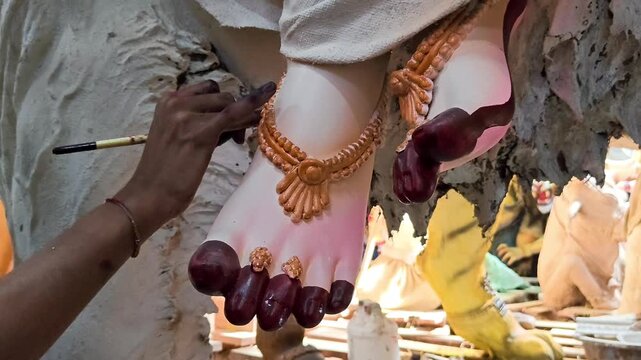 Indian artist hand painting details on goddess durga idol for navaratri festival