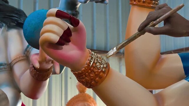 Indian artist hand painting details on goddess durga idol for navaratri festival
