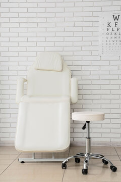 Medical aesthetics and skincare clinic, professional treatment chair and stool for dermatology or cosmetology procedures in a clean clinical office