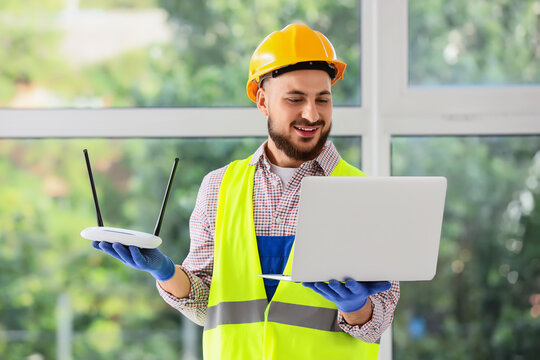 Internet installation and network setup, technician with laptop and wireless router for home connectivity and broadband service in modern building
