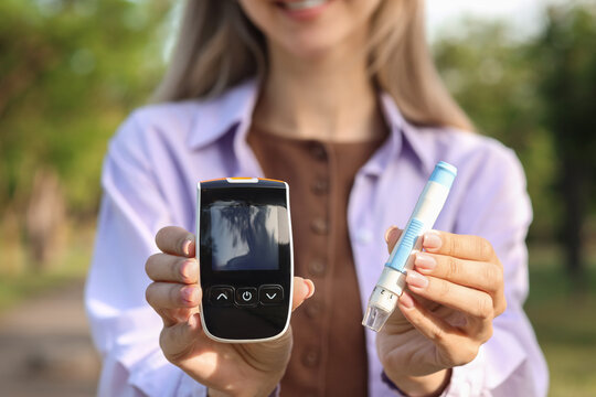Diabetes management and blood glucose monitoring, woman holding a glucometer and lancing device for daily health check in a park