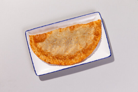 Fried cheburek on rectangular plate food preparation
