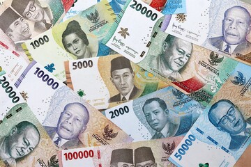 Indonesian rupiah money banknotes pile on table. Indonesia bills of IDR currency close up © Larysa