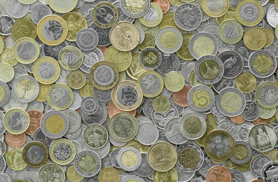 Macro shot showing many coins from worldwide locations, heaped. Assorted denominations