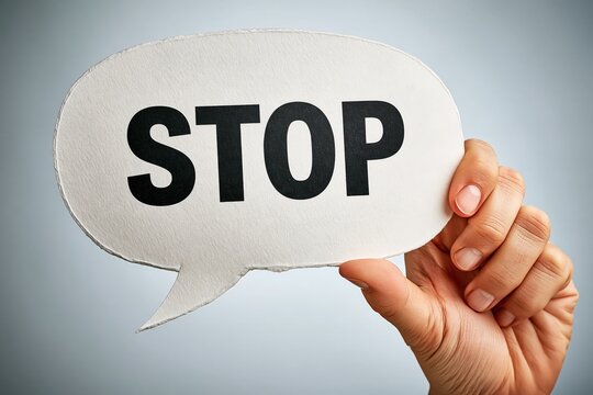 Hand holding speech bubble with stop sign symbol communication concept