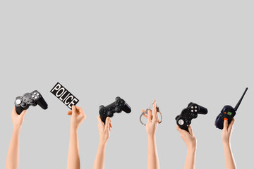 Gaming addiction and law enforcement, hands holding game controllers with police badge and handcuffs social issues and digital crime © Pixel-Shot