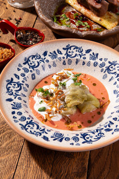 Cabbage rolls with sour cream and fried onions in ceramic bowl