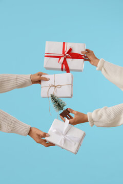 Female hands with Christmas gifts, letters and decorative fir tree on color background