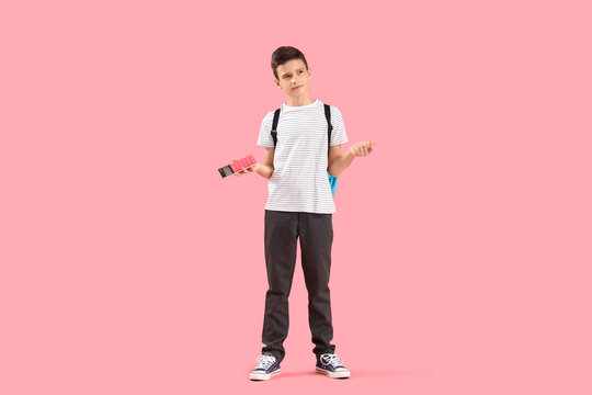 Education stress and math anxiety, student holding calculator with confused expression on pink background