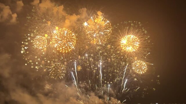 A grand, triple-burst pyrotechnic display against a jet-black sky. Three massive fireworks explode in rapid succession, unfurling like elaborate, multi-colored palm trees.