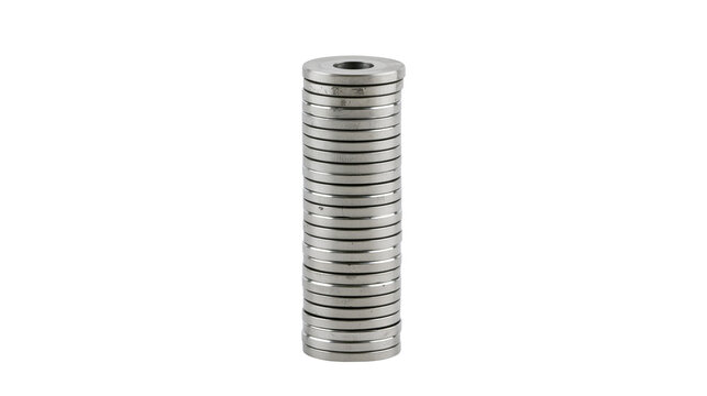 Isolated tall stack of shiny silver metal ring magnets for industrial and mechanical use