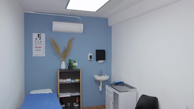 A camera tilt down reveals a generic medical office in Mexico City, including an examination table, eye chart, and washbasin.