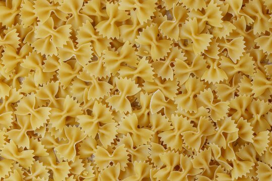 Uncooked Farfalle Pasta, Bow-Tie Macaroni Creating a Lively and Textured Background