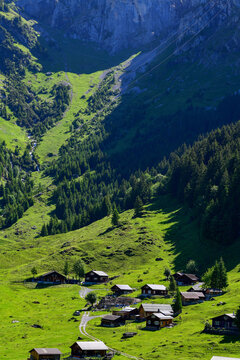 Die idyllische Alp &Auml;sch mit traditionellen Alph&uuml;tten am Fu&szlig;e einer imposanten Felswand im Sch&auml;chental, Kanton Uri, Schweiz