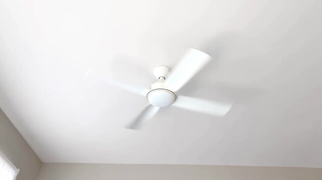 Static shot of ceiling fan spinning with motion blur showing rotating blades and light fixture in residential bedroom interior during daytime minimal white decor