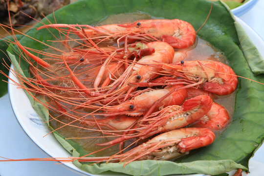 ooked large red shrimp served on lotus leaf