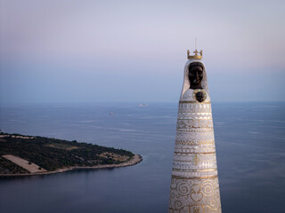 Aerial view of Our Lady of Loretto mosaic statue on Gaj hill overlooking Adriatic Sea and coast during dusk, Primosten, Croatia © ventura