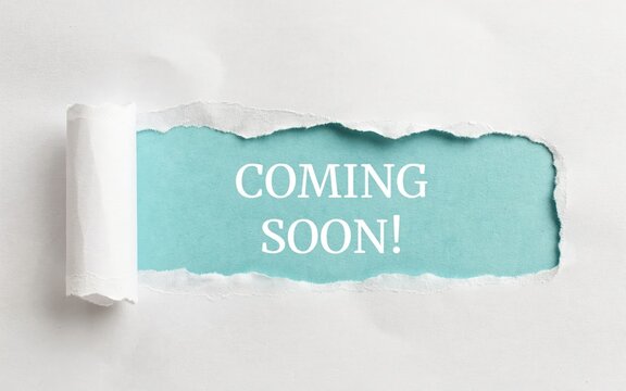 Coming soon text revealed through torn white paper exposing blue background. Perfect marketing concept for product launches.