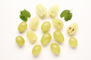 Fototapeta premium Fresh ripe grapes and green leaves on white background, flat lay