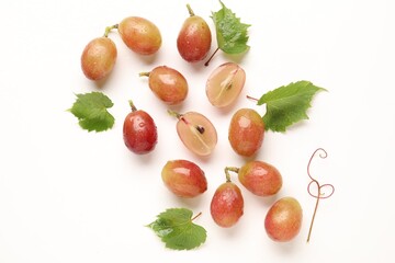 Naklejka premium Fresh ripe grapes and green leaves on white background, flat lay