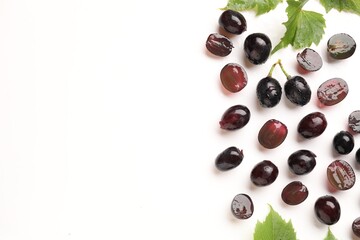 Naklejka premium Fresh ripe grapes and green leaves on white background, flat lay. Space for text