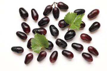 Naklejka premium Fresh ripe grapes and green leaves on white background, flat lay