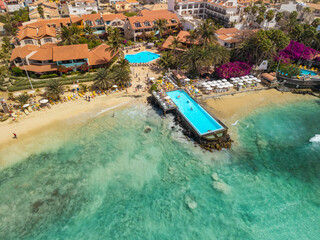 Fototapeta premium Aerial view of beachfront resort and pool at Santa Maria beach in Sal Cape Verde