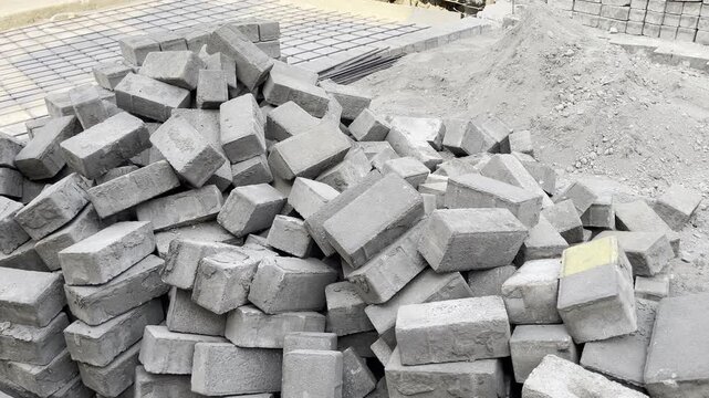 Pile of grey concrete bricks on construction site background
